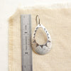 The pakal teardrop cutout earring next to a ruler for size reference