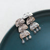 The pakal trio labradorite dangle post earrings styled on a blue plate