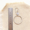 A talara sun hoop earring next to a ruler for size reference