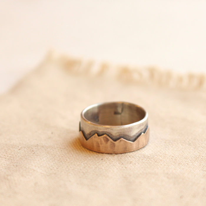 Oxidized bronze and silver mountain ring styled on tan linen