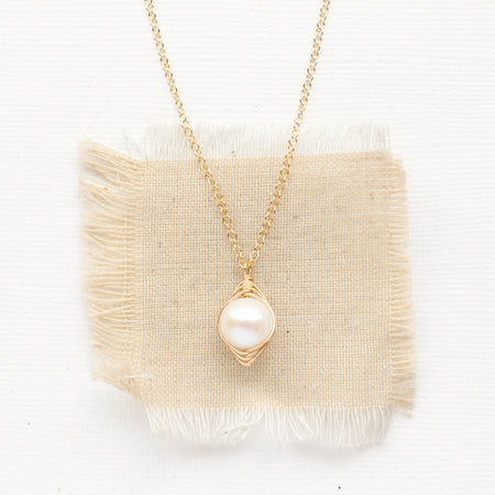 The perfect pearl gold necklace styled on tan linen