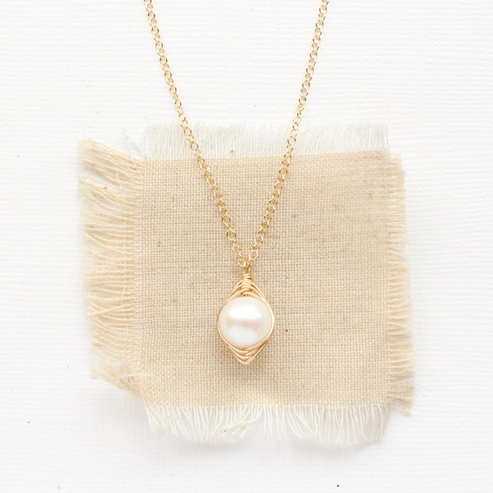 The perfect pearl gold necklace styled on tan linen
