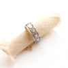 The ever expanding stamped silver band ring styled on a roll of tan linen