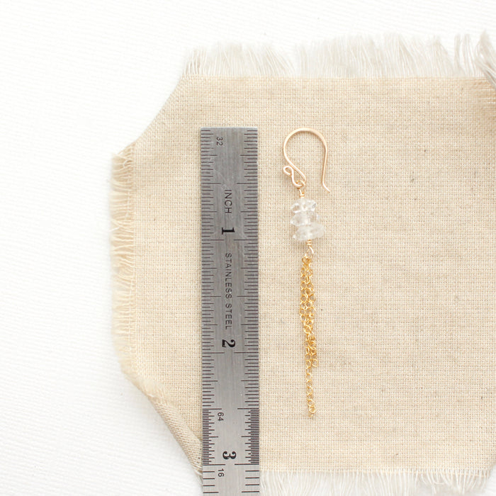 A stacked herkimer diamond gold tassel earring next to a ruler for size reference