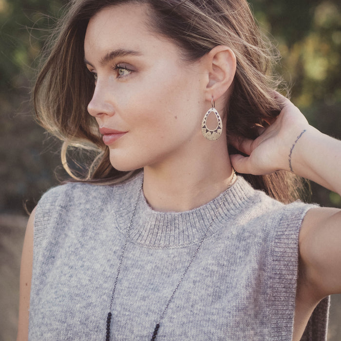 A model wearing the pakal teardrop cutout earrings