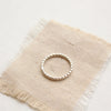 Sterling silver beaded stacking ring styled on tan linen