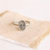 Stamped silver ring with burst deisgn styled on tan linen