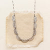The asmi silver full collar necklace styled on tan linen