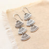 The asmi trio triangle long earrings styled on tan linen
