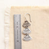 An asmi trio triangle earring next to a ruler for size reference