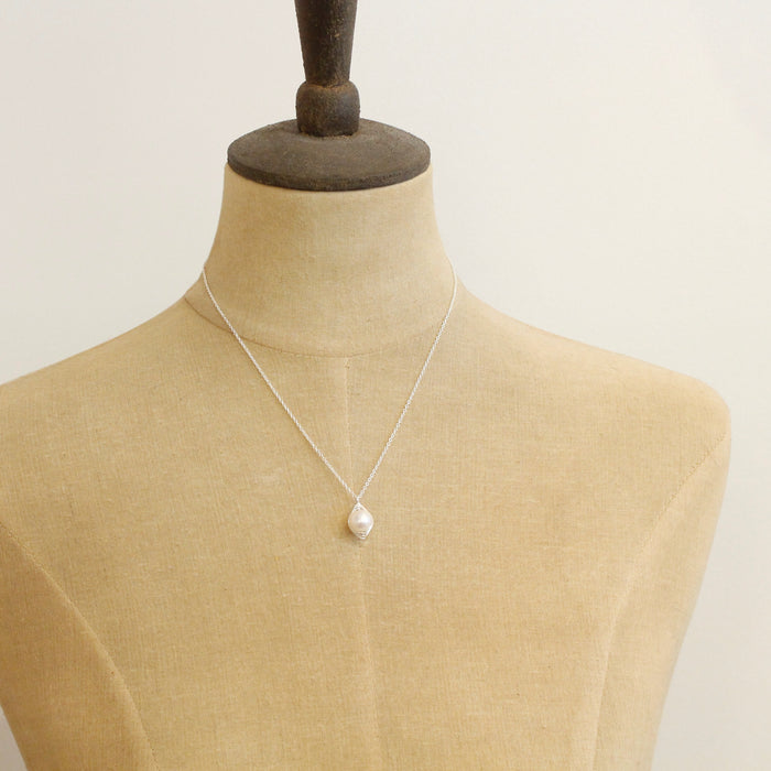 A mannequin wearing the bright silver perfect pearl necklace