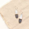 The rustic dipped teardrop mixed metal earrings styled on tan linen
