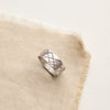 The embrace the choas ring styled on tan linen