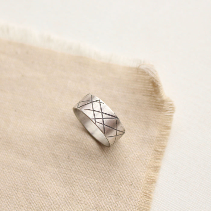 The embrace the choas ring styled on tan linen