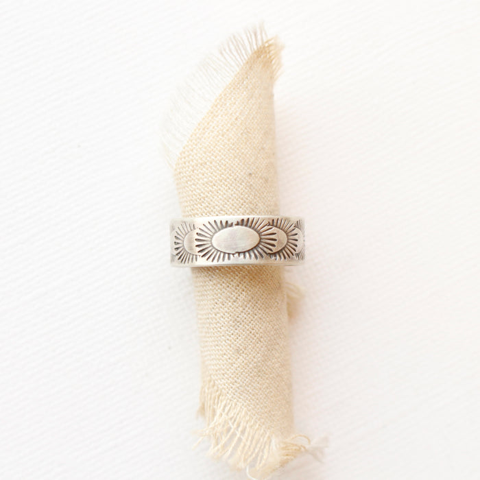 The ever expanding stamped band ring styled on a roll of tan linen