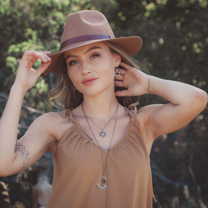 The feathered sun necklace being worn on a model