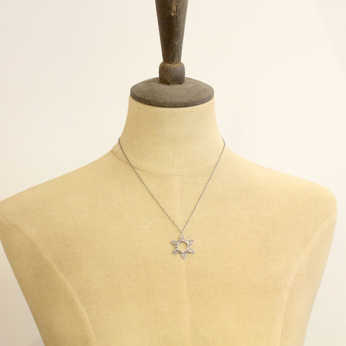 A mannequin wearing the feathered sun necklace