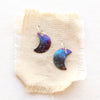The fire painted copper moon earrings styled on tan linen