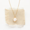 The perfect pearl gold necklace styled on tan linen