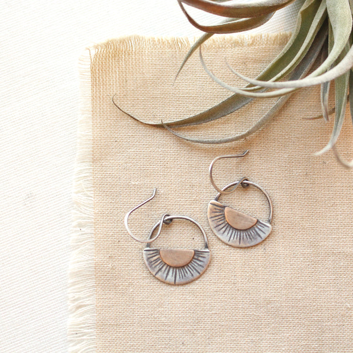 The happy half sun earrings styled on tan linen with an air plant