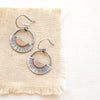 The happy half sun earrings styled on tan linen