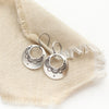 The jolie hoop earrings styled on tan linen