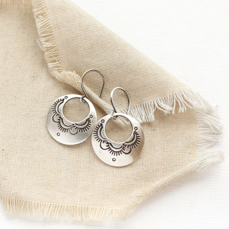 The jolie hoop earrings styled on tan linen