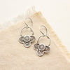 The layered talara loop earrings styled on tan linen