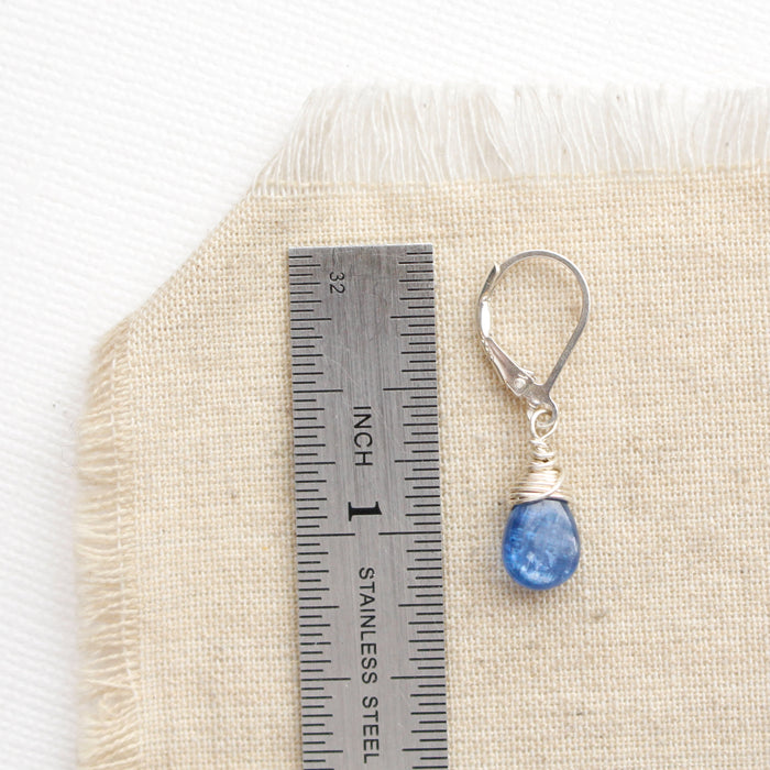 A kyanite drop earring next to a ruler for size reference