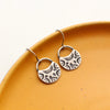 The midnight bloom earrings styled on a yellow plate