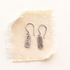 mini sun bar earrings on tan linen