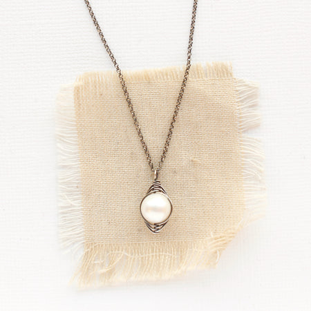 The oxidized silver perfect pearl necklace styled on tan linen