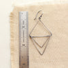 An oxidized silver triple triangle hoop earring next to a ruler for size reference