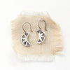 The pakal moon earrings styled on tan linen