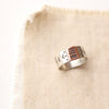 The rustic stamped bronze and silver ring styled on tan linen