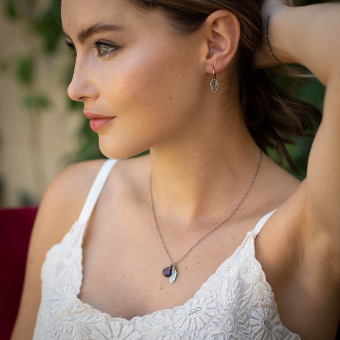 A model wearing the stamped silver feather lobe hugger earrings 