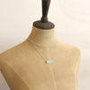 A mannequin wearing the silver layered mountain bar necklace