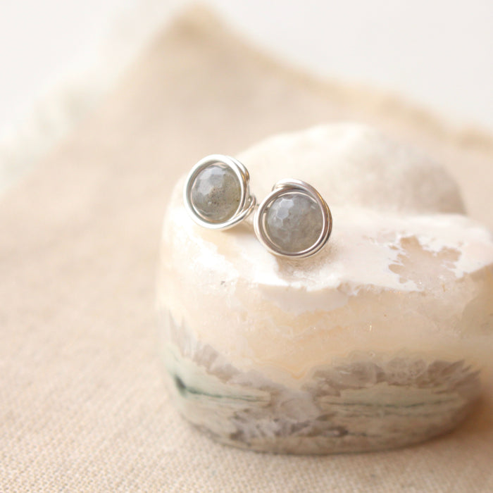 The silver wrapped labradorite post earrings styled on a crystal