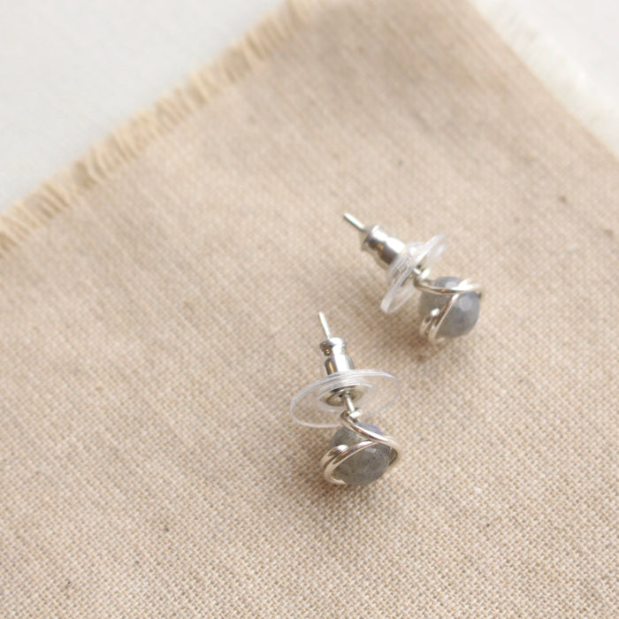 The silver wrapped labradorite post earrings styled to show the comfort clutch ear backs