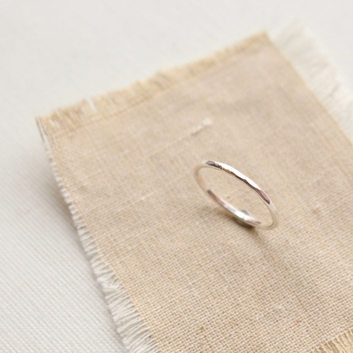 The silver stacking ring styled on tan linen