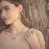 The columbine hoop earrings being worn by a model