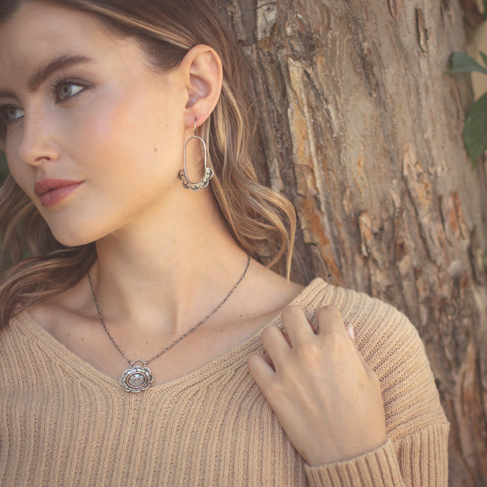 The columbine hoop earrings being worn by a model