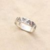 The stamped triangle silver ring styled on tan linen