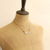 A mannequin wearing the still i rise bar necklace