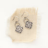 The talara bloom earrings styled on tan linen