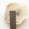 A talara sun post earring next to a ruler for size reference