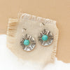 The turquoise jolie earrings styled on tan linen