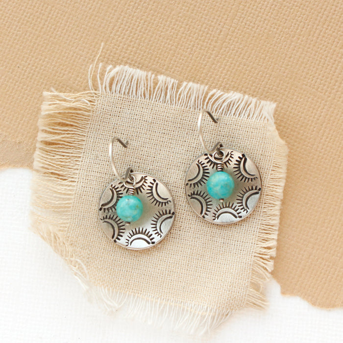 The turquoise jolie earrings styled on tan linen