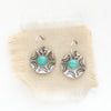 The turquoise jolie earrings styled on tan linen