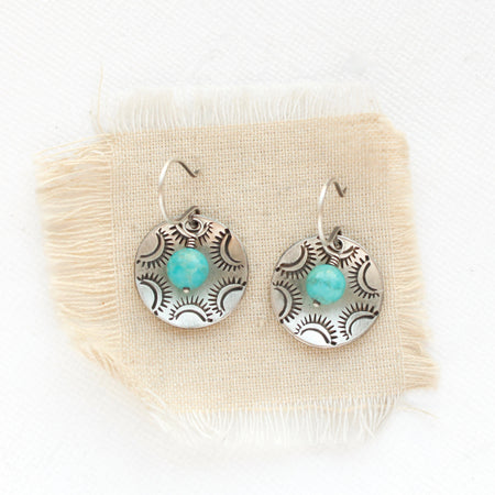 The turquoise jolie earrings styled on tan linen